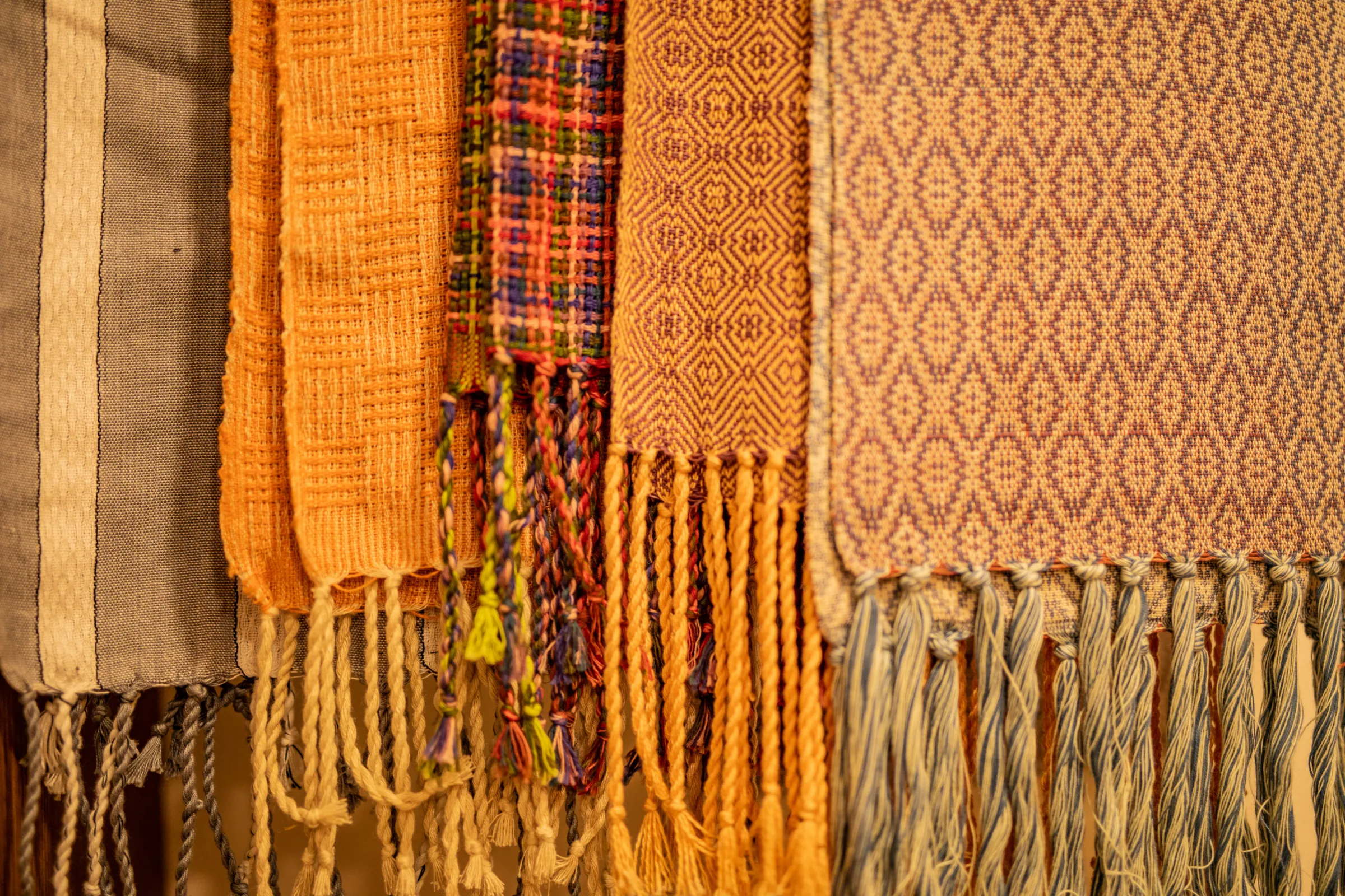 Handwoven scarves hanging in the studio