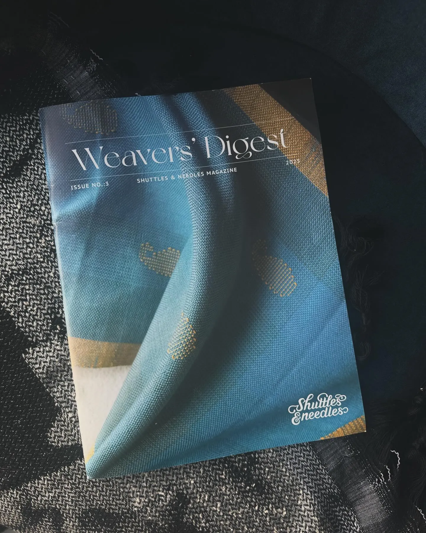 Weavers’ Digest magazine, issue 3, lying on handwoven cloth