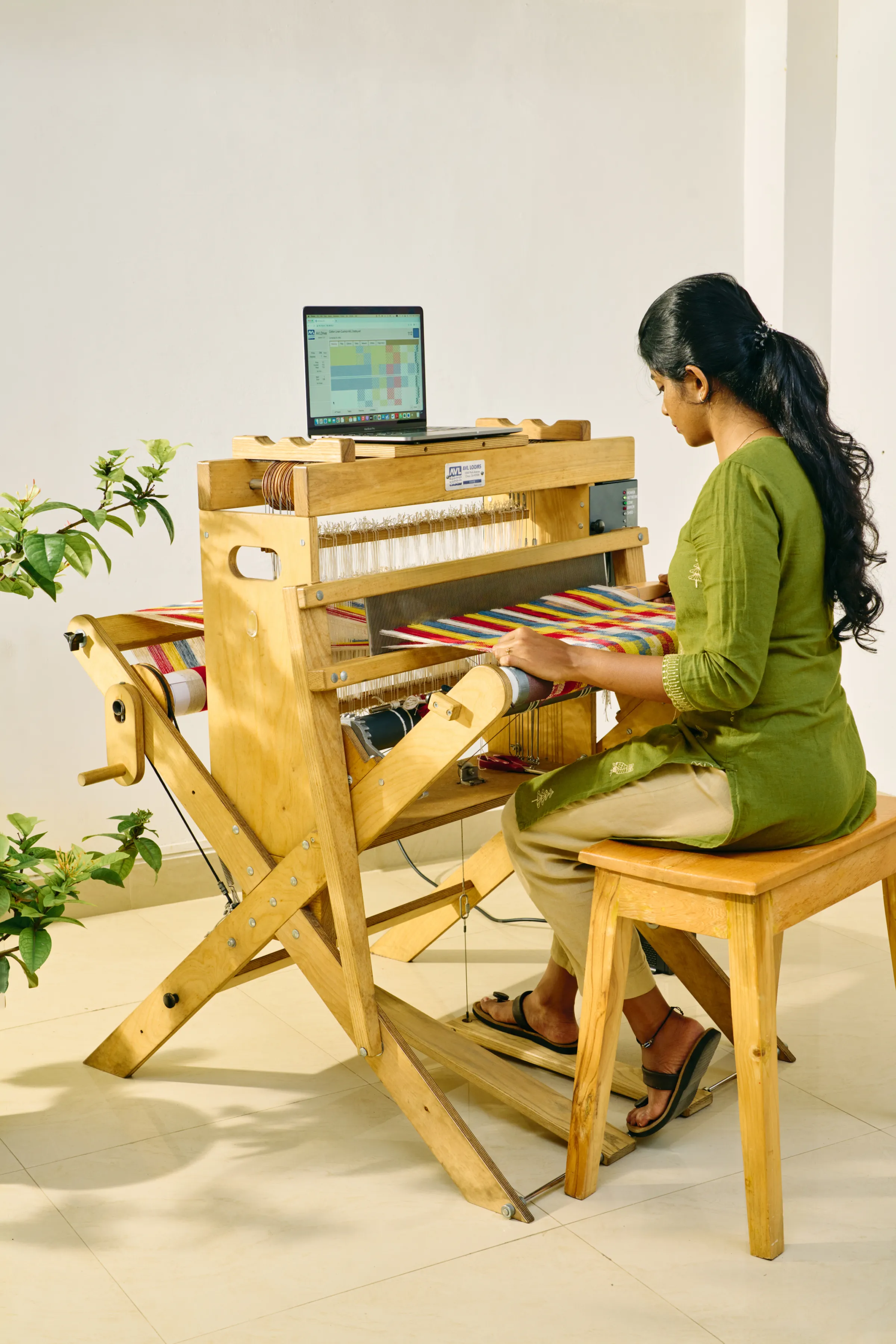A designer working on a weaving project in the studio
