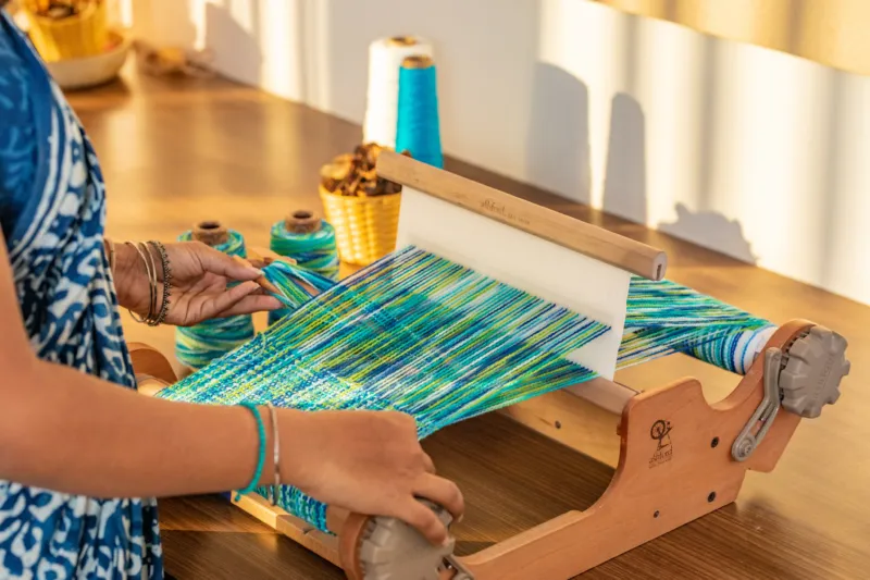Weaving on a rigid heddle loom with blue and green yarn