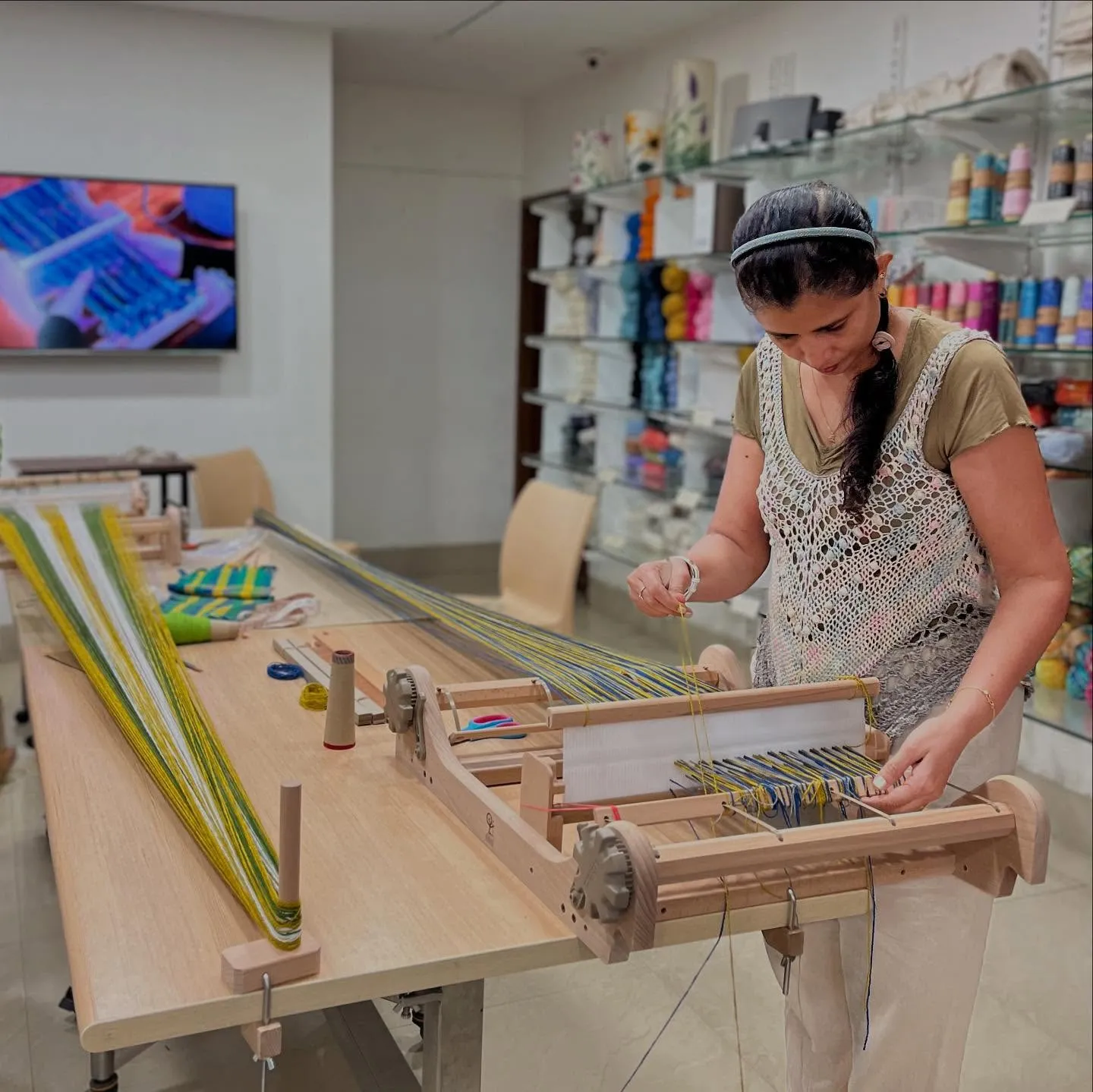 A participant weaving on a table loom