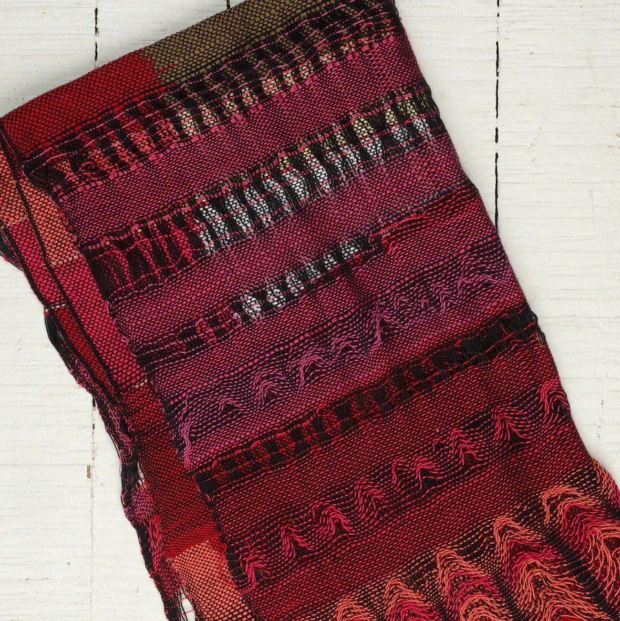 A red and magenta SAORI-woven scarf with textured stripes